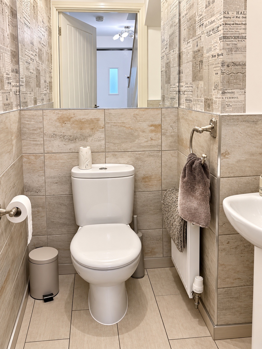 WC and basin with patterned wallpaper and tiled lower walls following cleaning